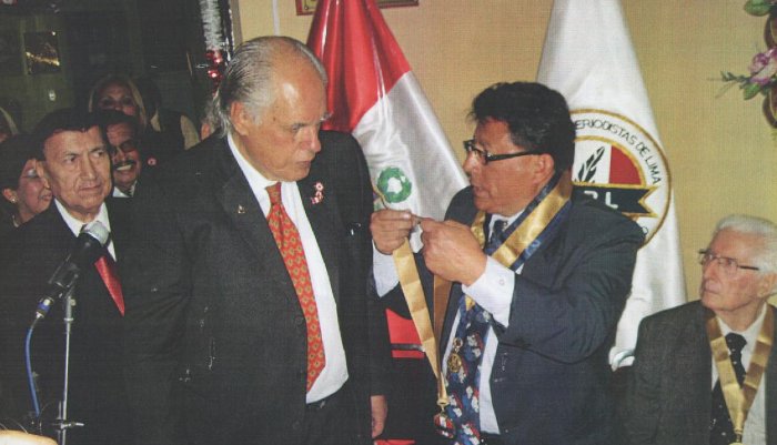 Preciso momento que el Decano CRPL Oscar Olórtegui coloca la "Medalla Honor al Mérito" al Director de la Revista "GENTE" Enrique Escardó V-G Preciso momento que el Decano CRPL Oscar Olórtegui coloca la "Medalla Honor al Mérito" al Director de la Revista "GENTE" Enrique Escardó V-G