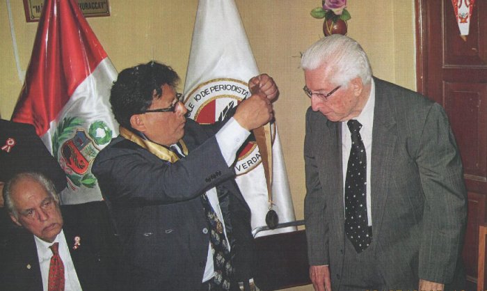 El Decano del CRPL Oscar Olórtegui, coloca la "Medalla Honor al Mérito" al Dr. Javier Alva Orlandini, forjador de la Ley de la Colegiación del Periodista (Ley 23221)